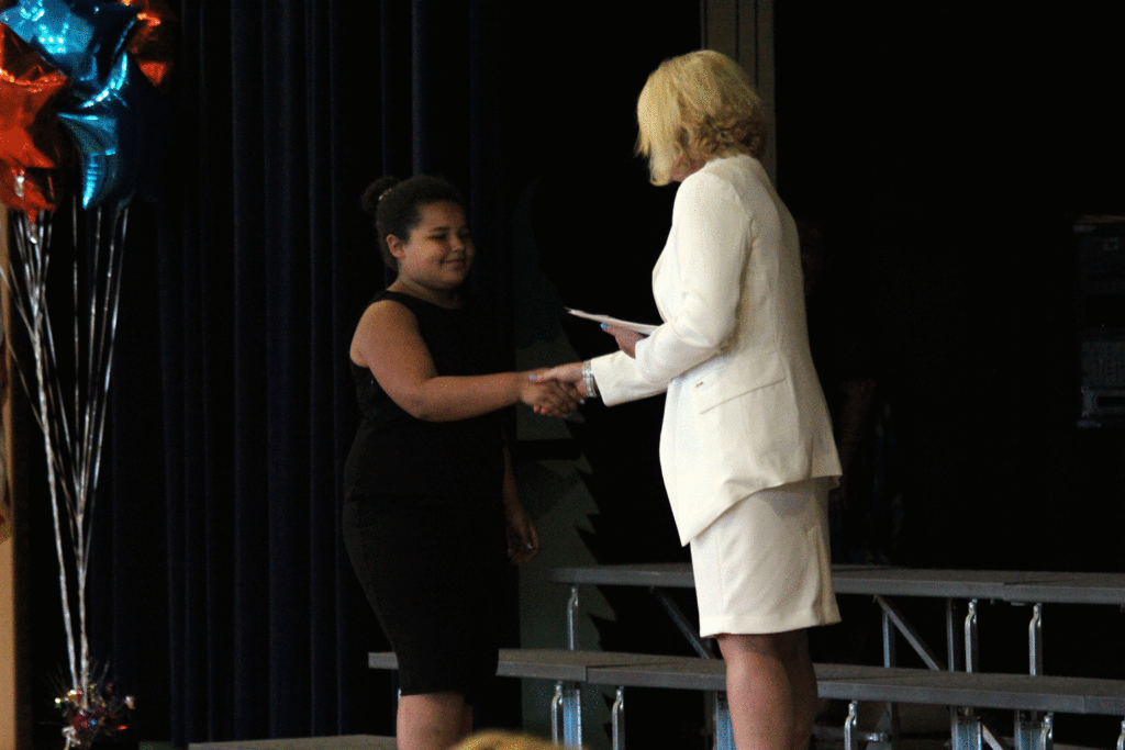 Student receives certificate from Mrs. Schlenker