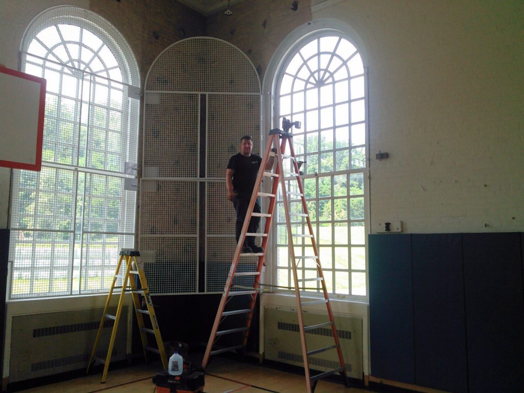 Window grates being reinstalled in the Middle School Gym