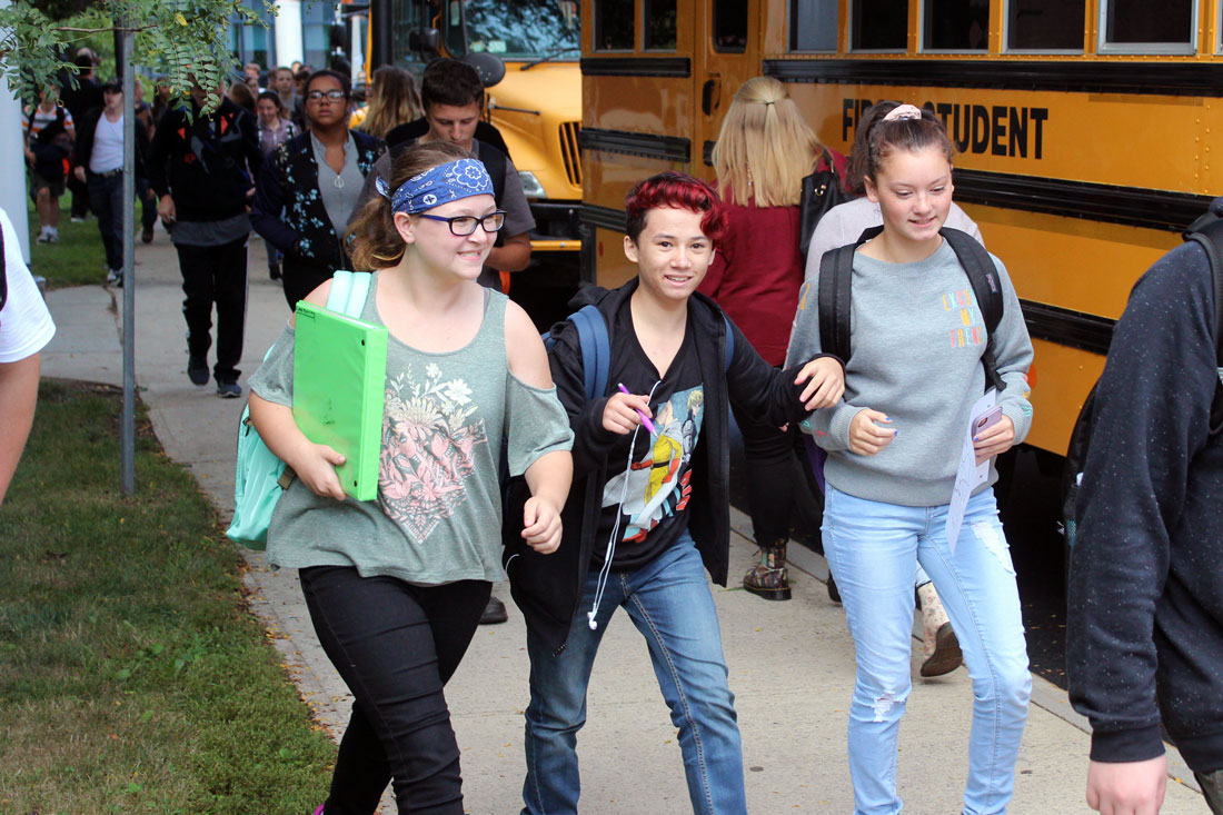 three high school students walking to bus