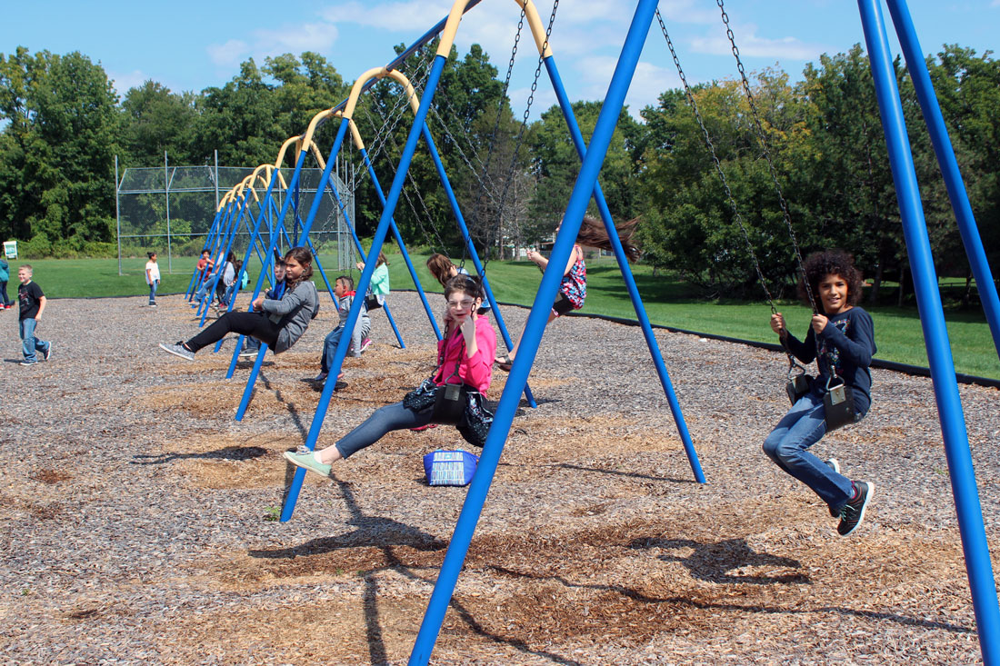 elementary students on the swings