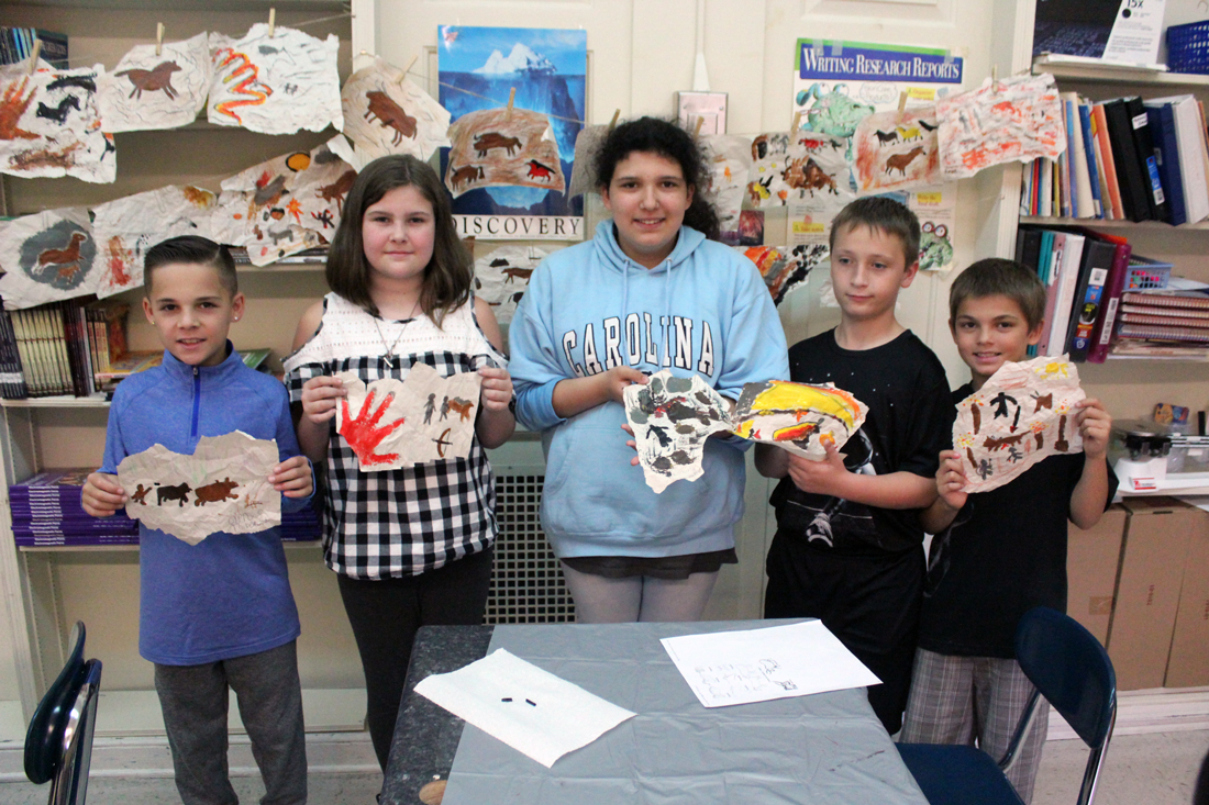 students show off thier finished paintings