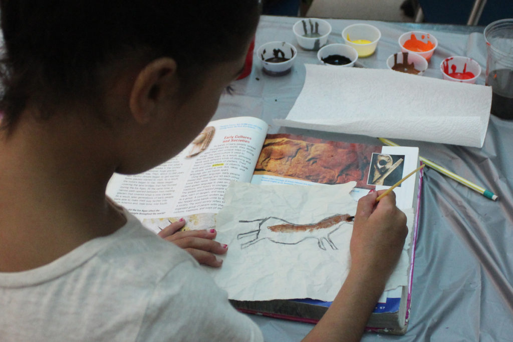 students painting animal in cave painting style