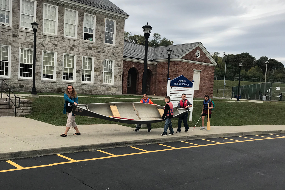 students carrying canoe