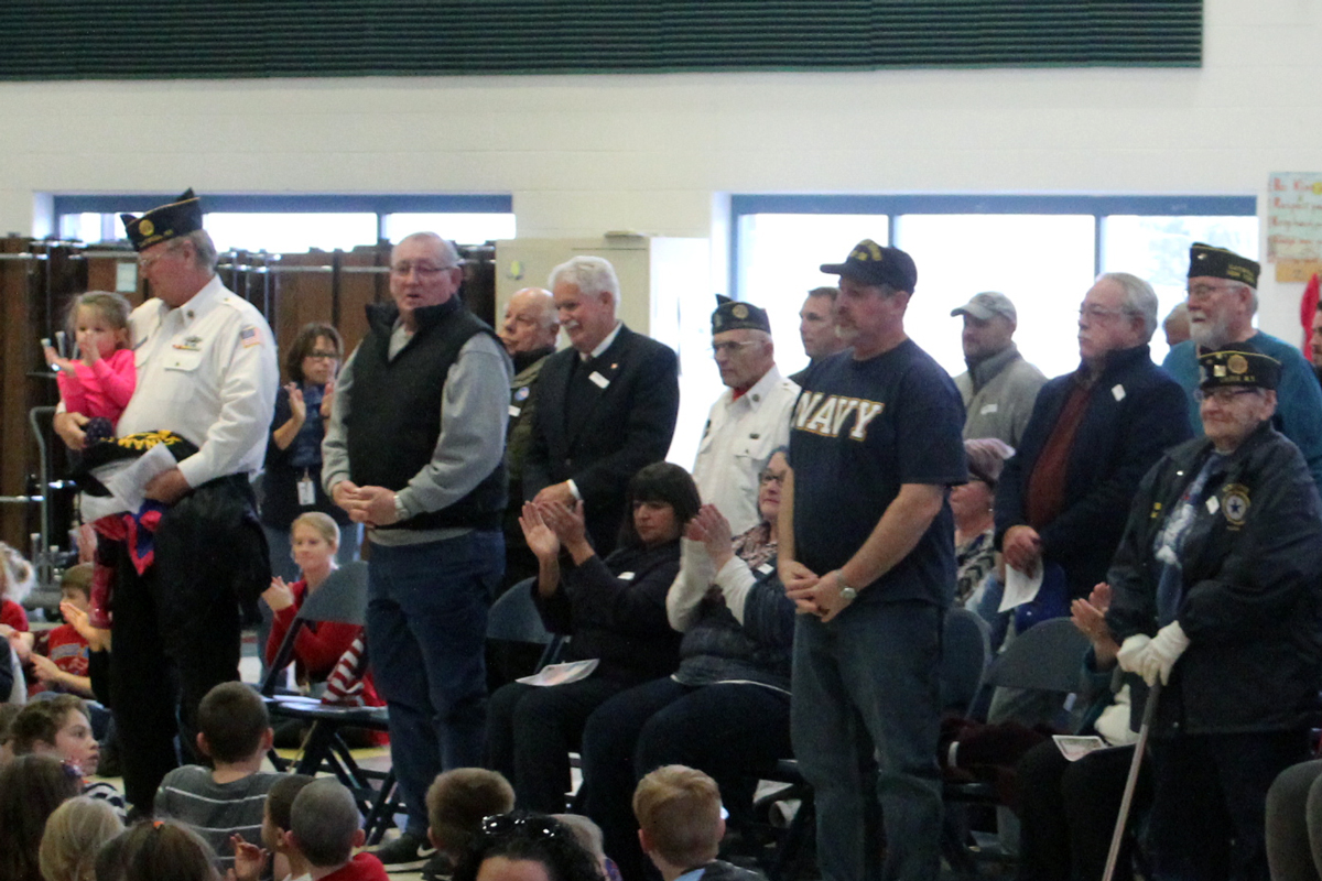 Veterans stand to be recognized at CES Veterans Assembly