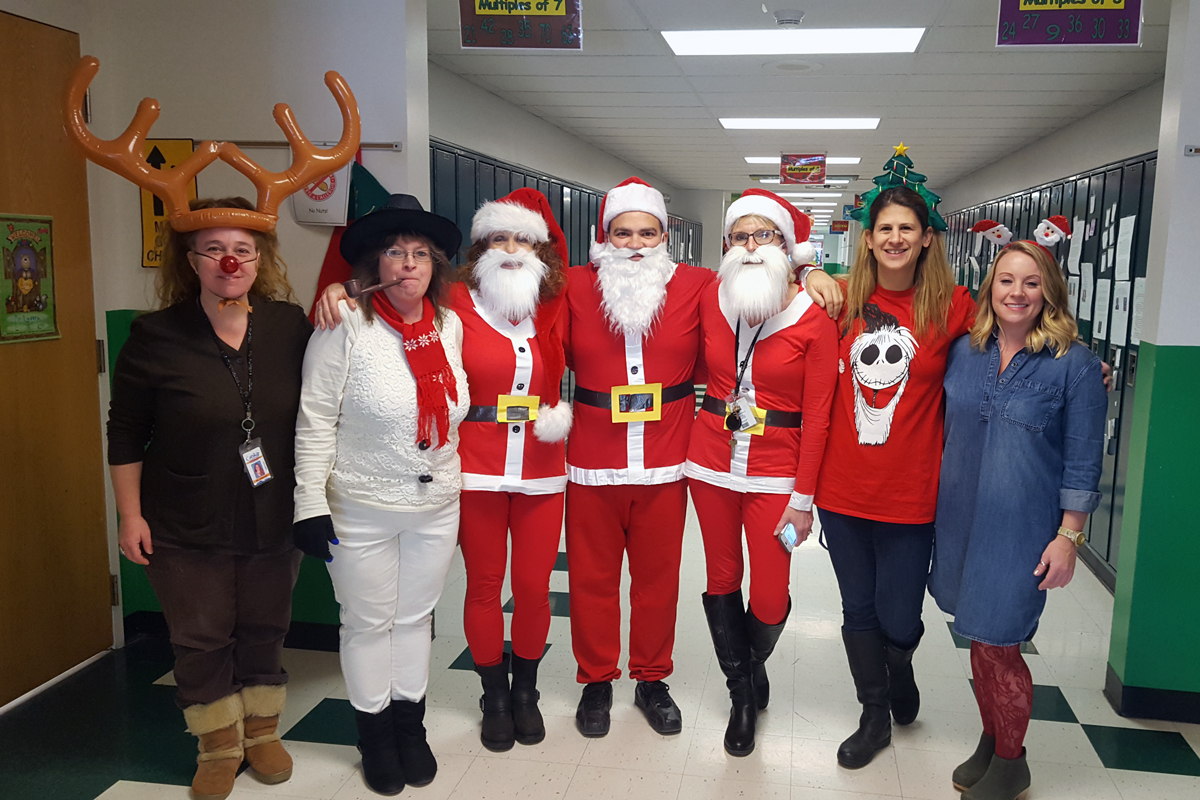 teachers dressed up like reindeer, snowman, santa, and elfs