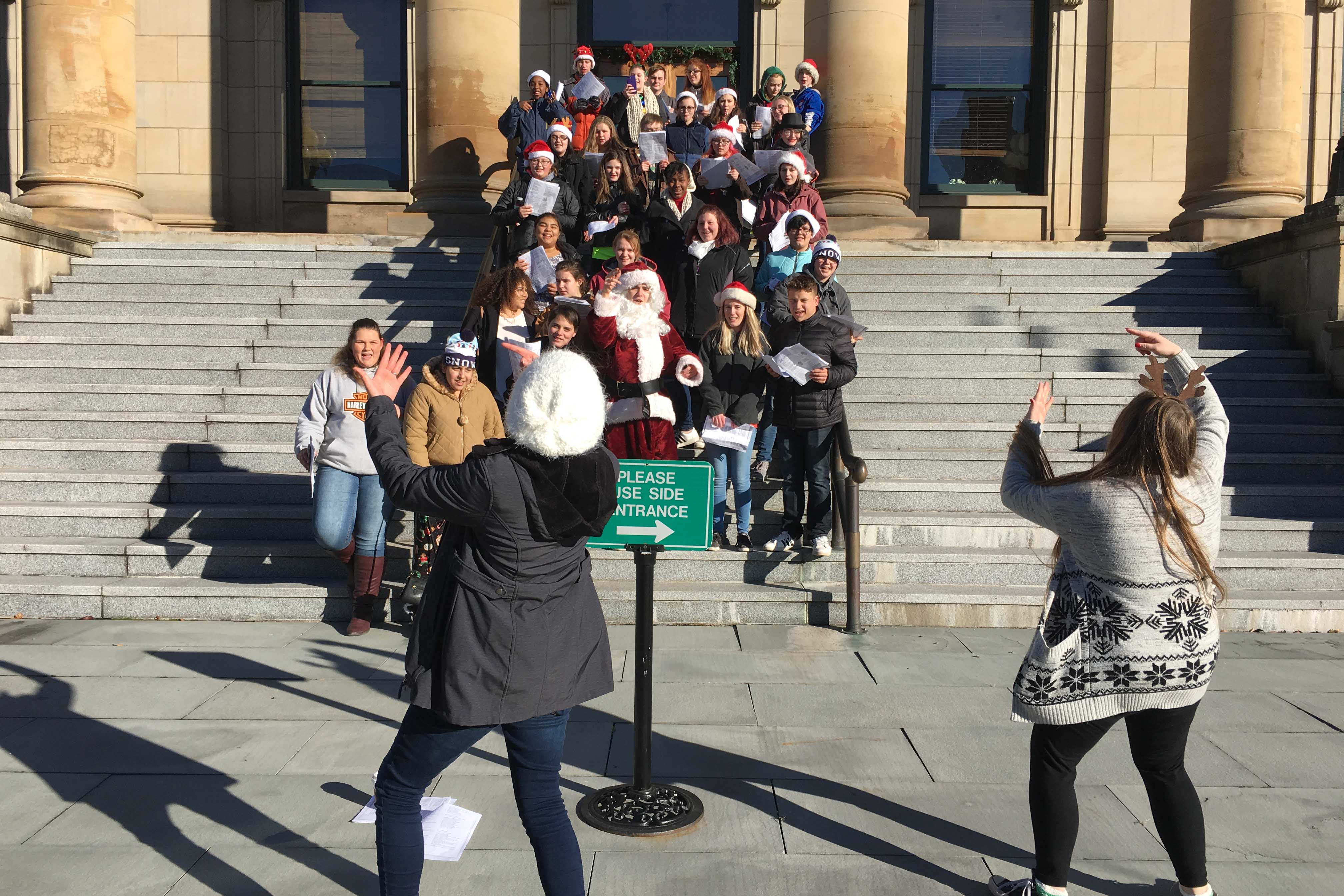 students caroling on courthouse steps