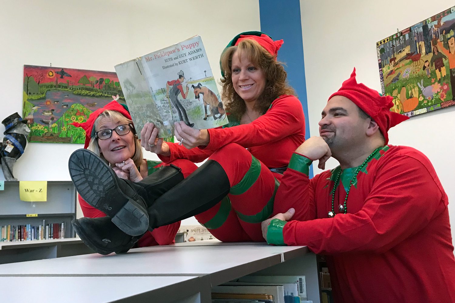 teachers dressed up like elves reading inthe CES library