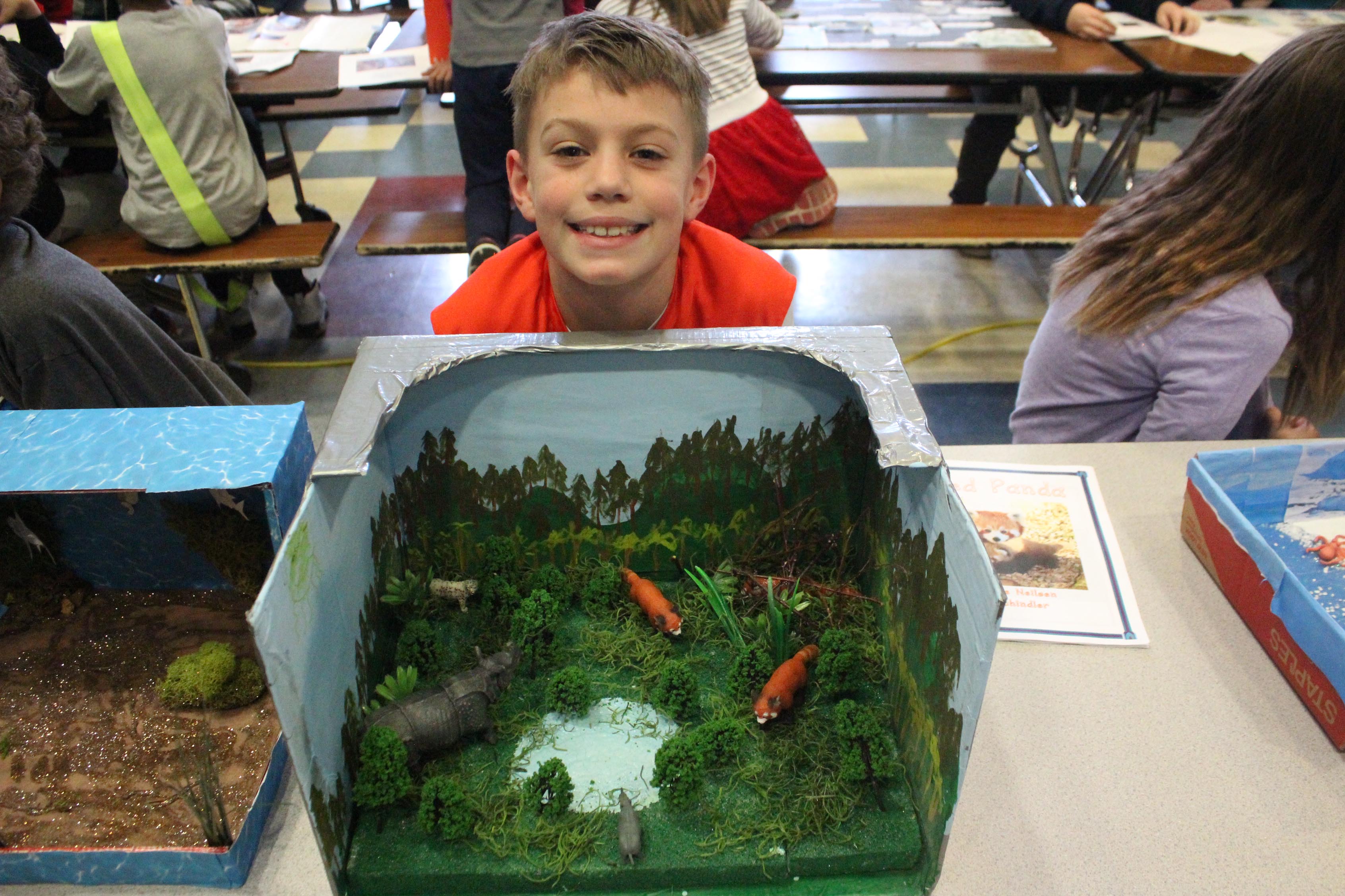 student poses with his diorama of faxes