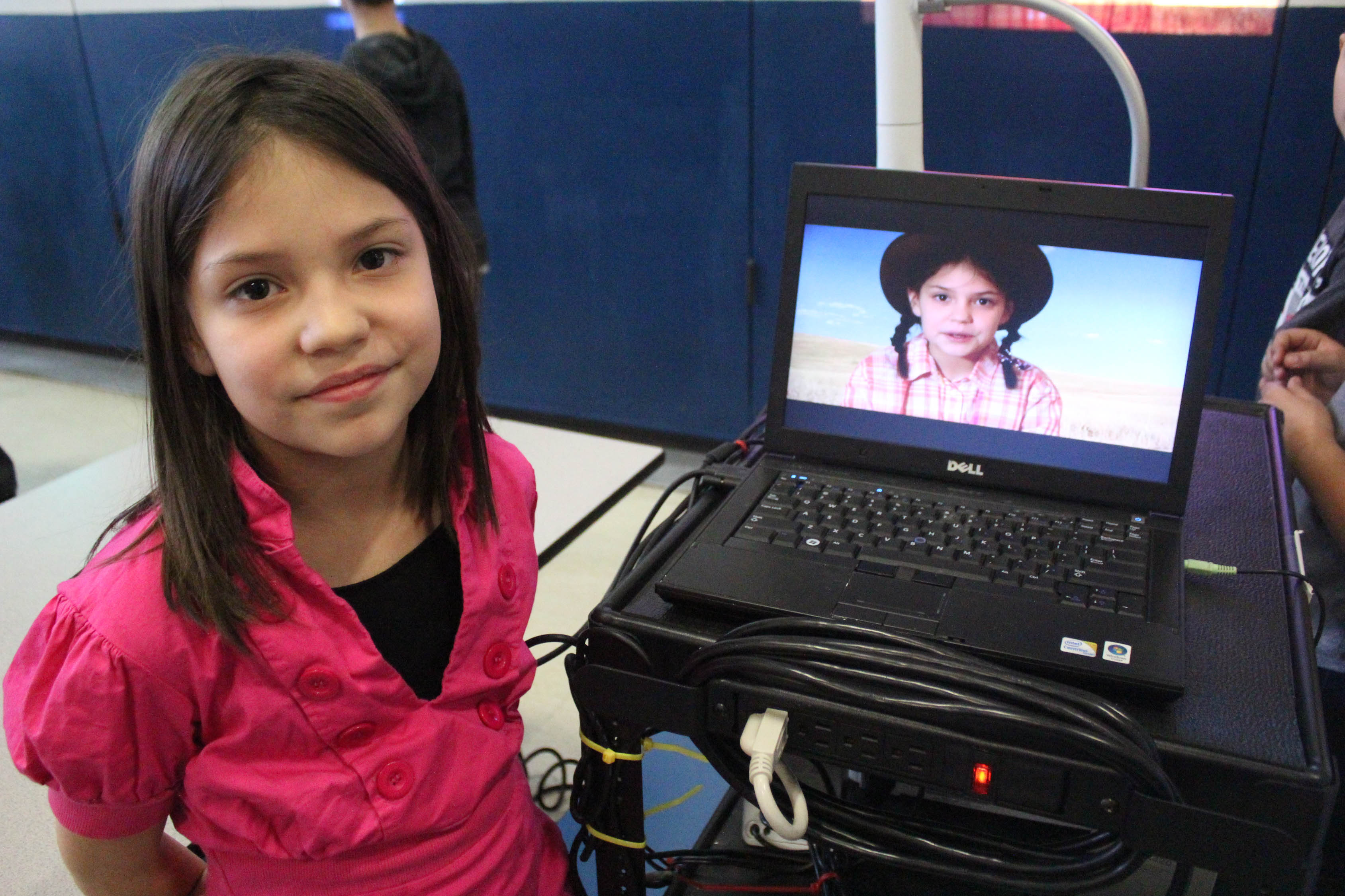 girl poses wit her video on computer
