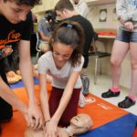 Student shows younger student CPR