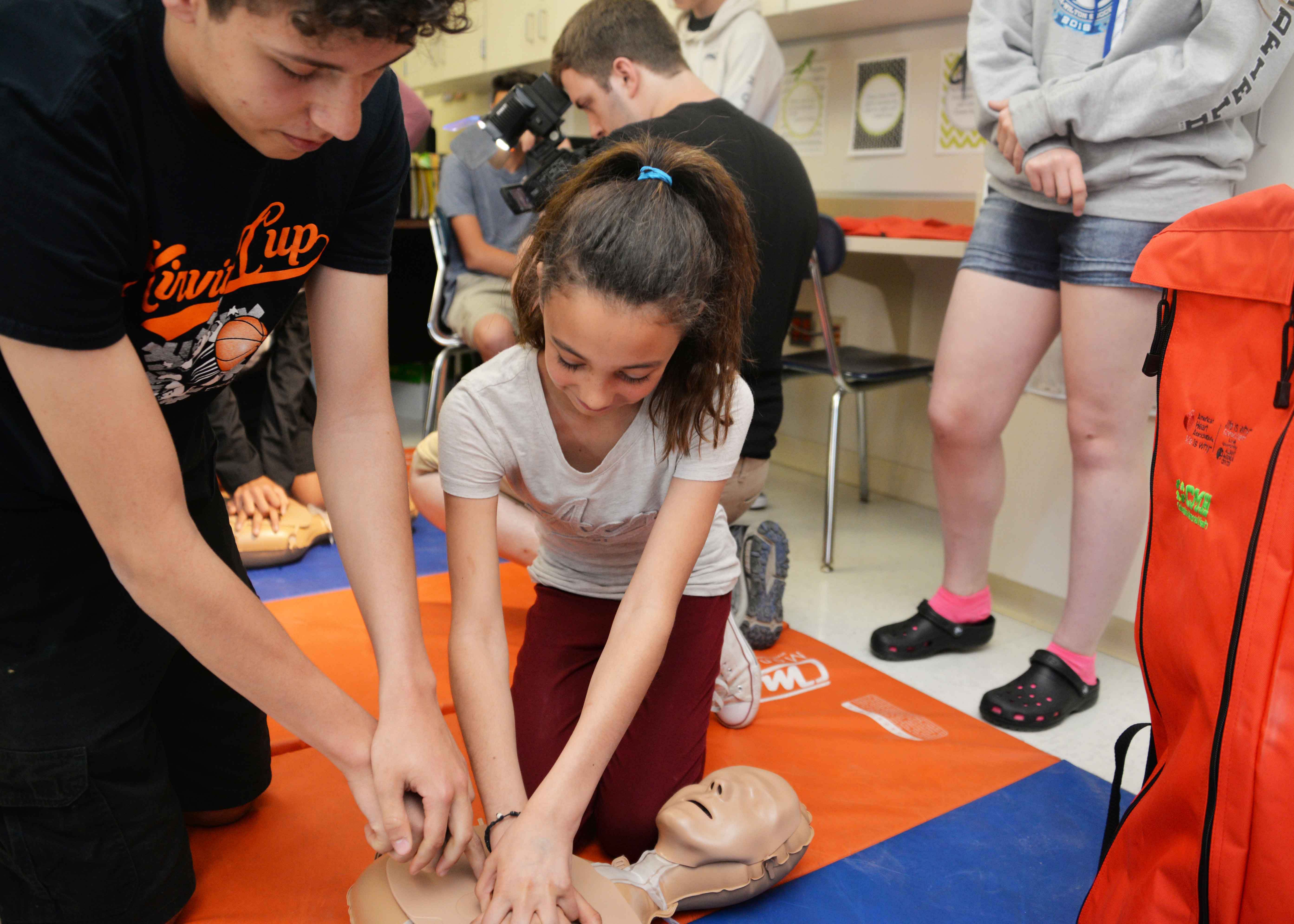 Student shows younger student CPR