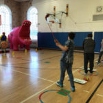 students take golf shots at giant cartoon character targets