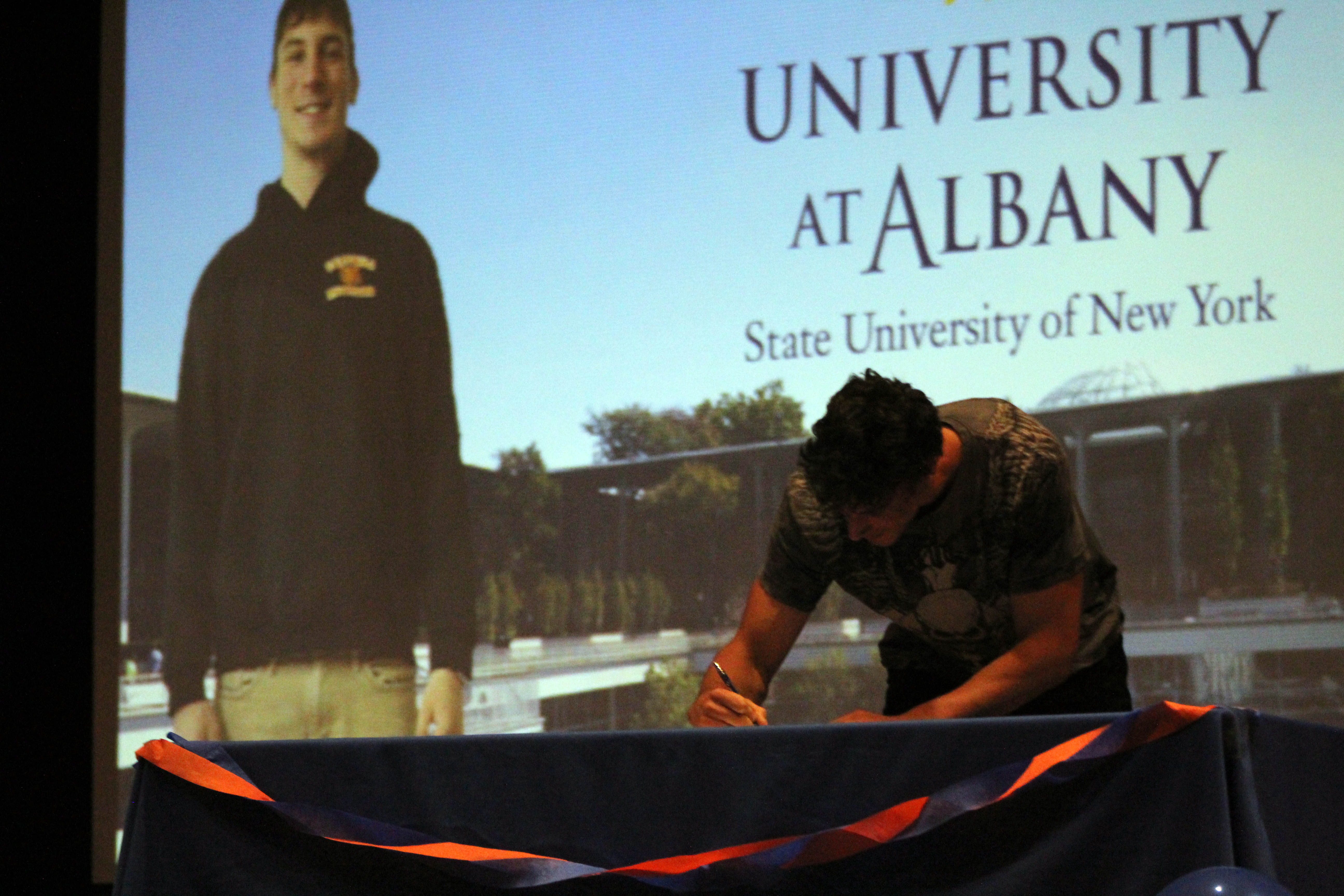 boy signs on senior signing day