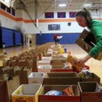 student packs bag with food in gym