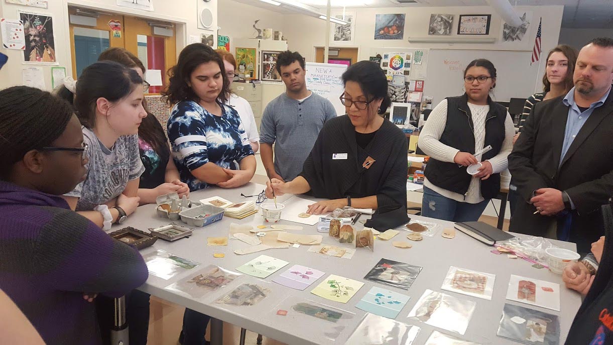 Ruby Silvious shows students her artwork at table