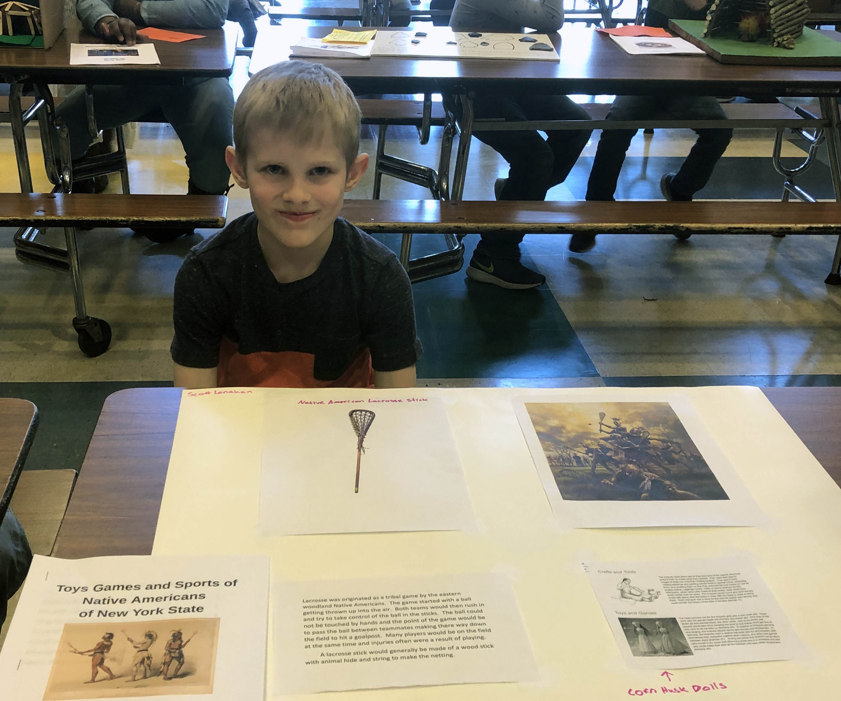 boy sitting at table with Native American display