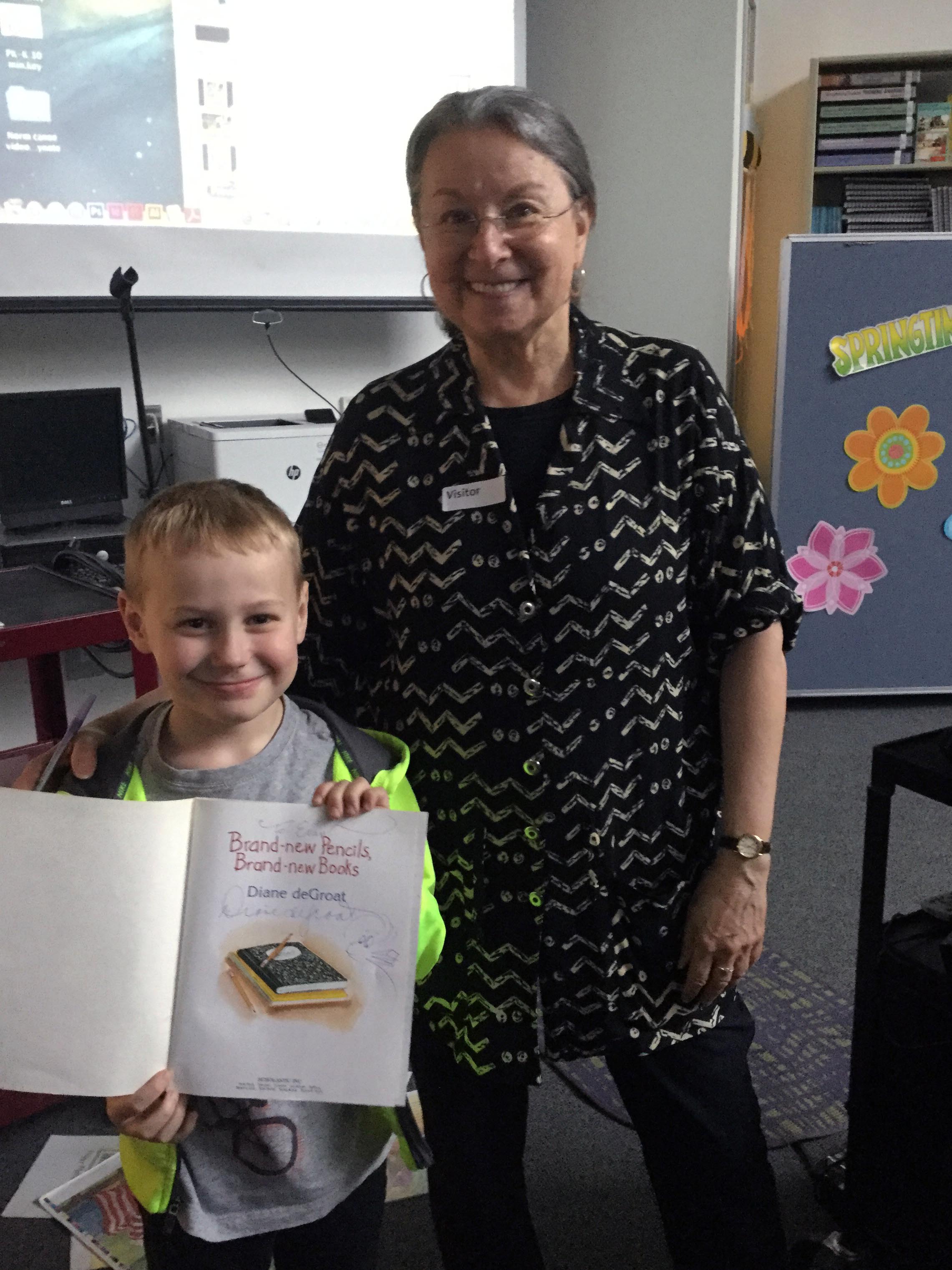 Diane DeGroat poses with student holding book