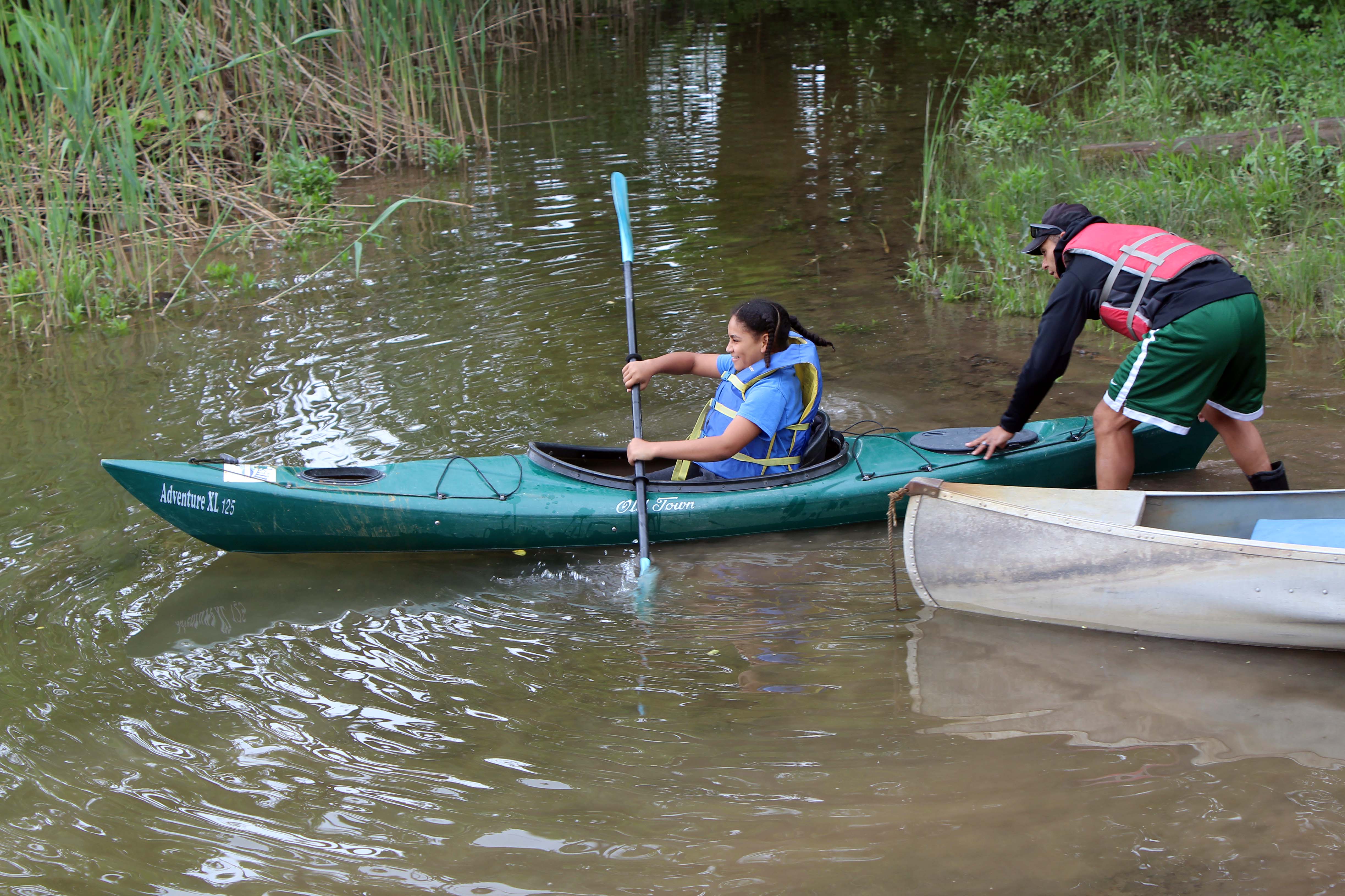 teacher launching girl in kayak