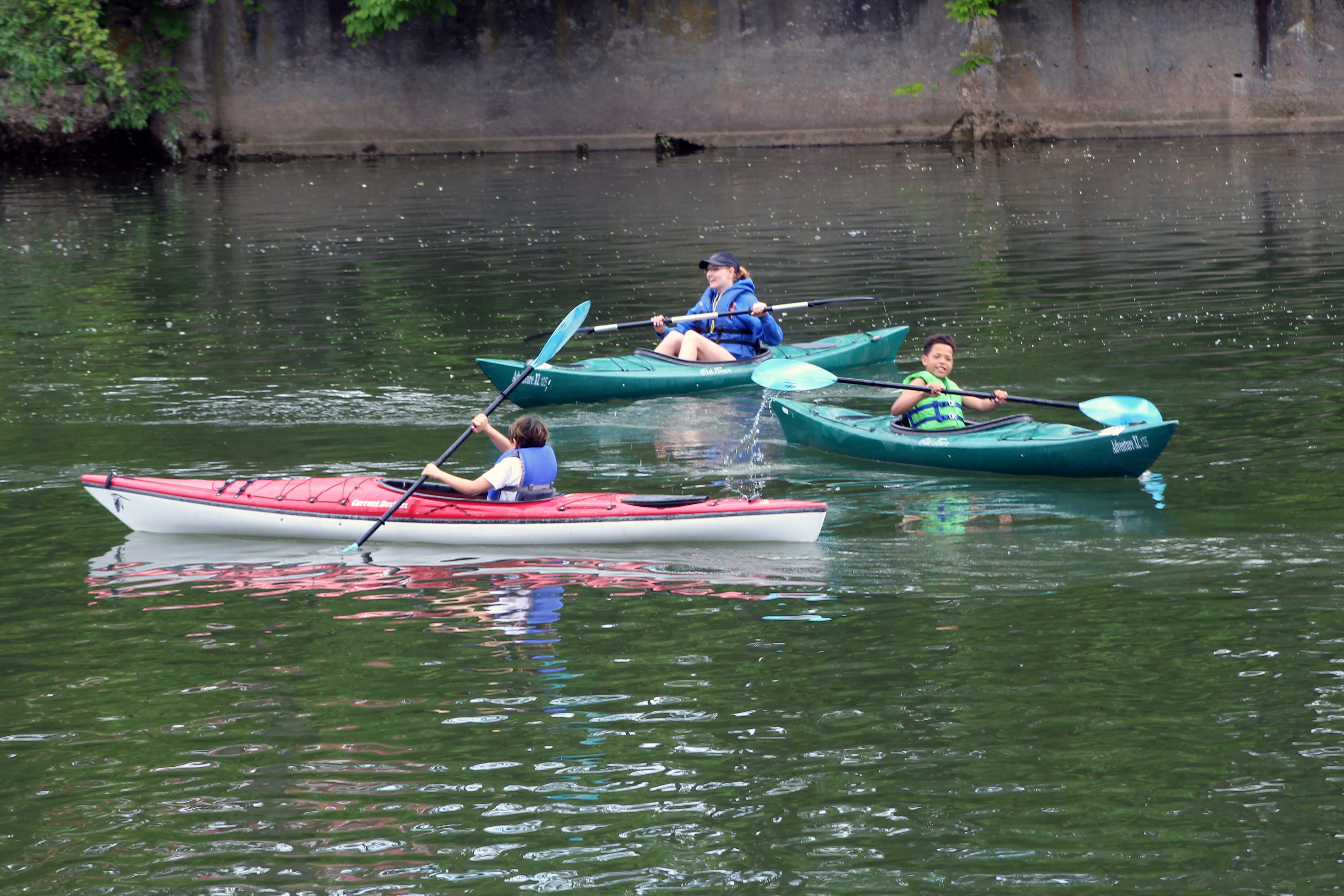 students nd teacher paddling on creek