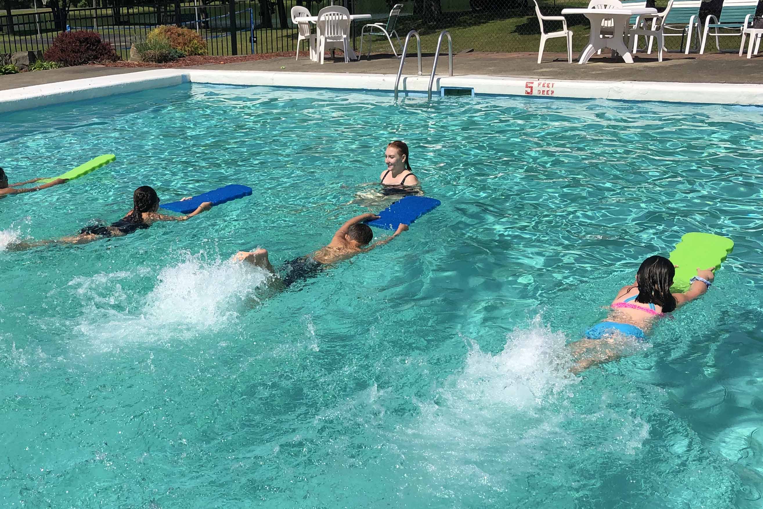 students swimming with kickboards