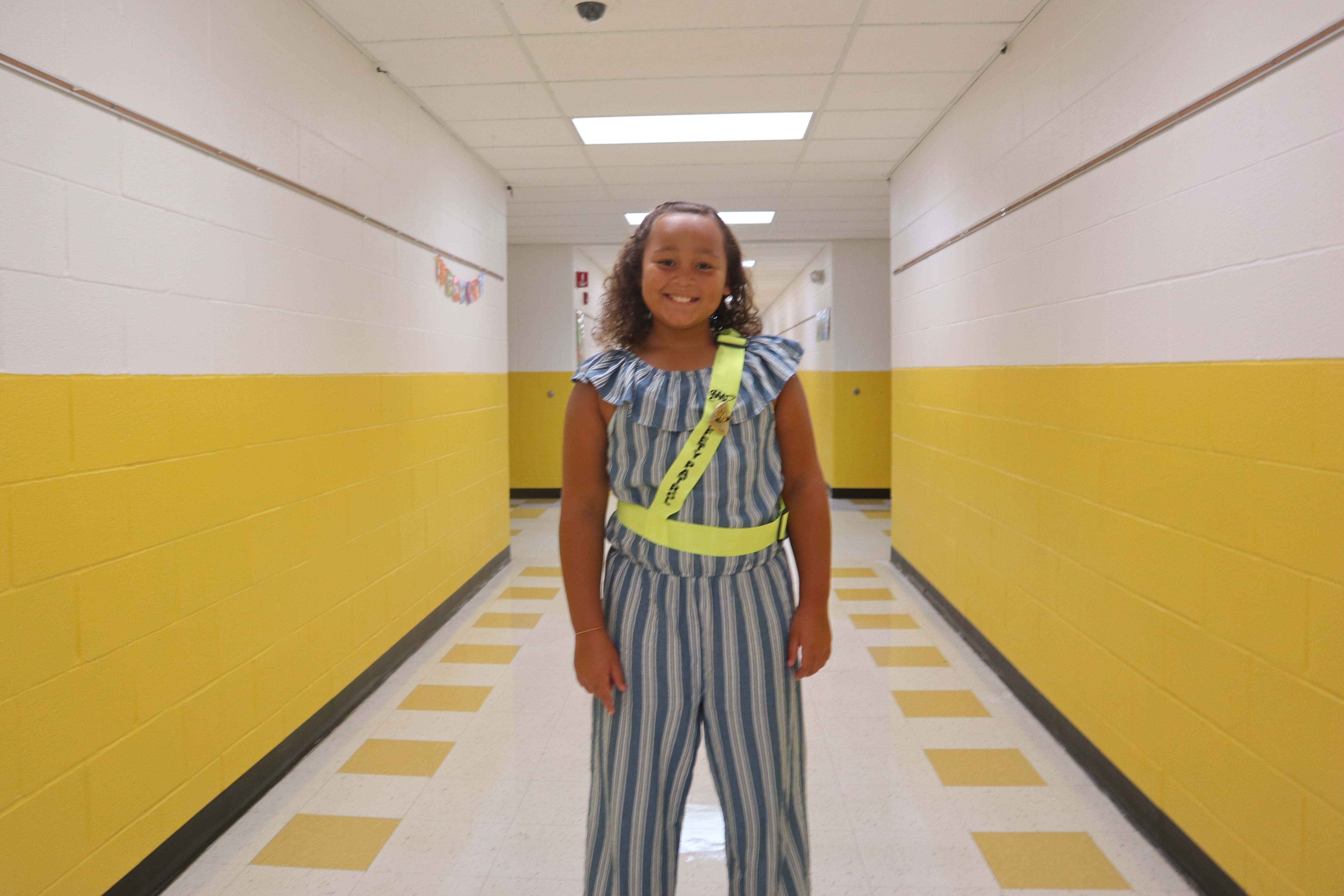 girl where safety patrol belt standing in hallway