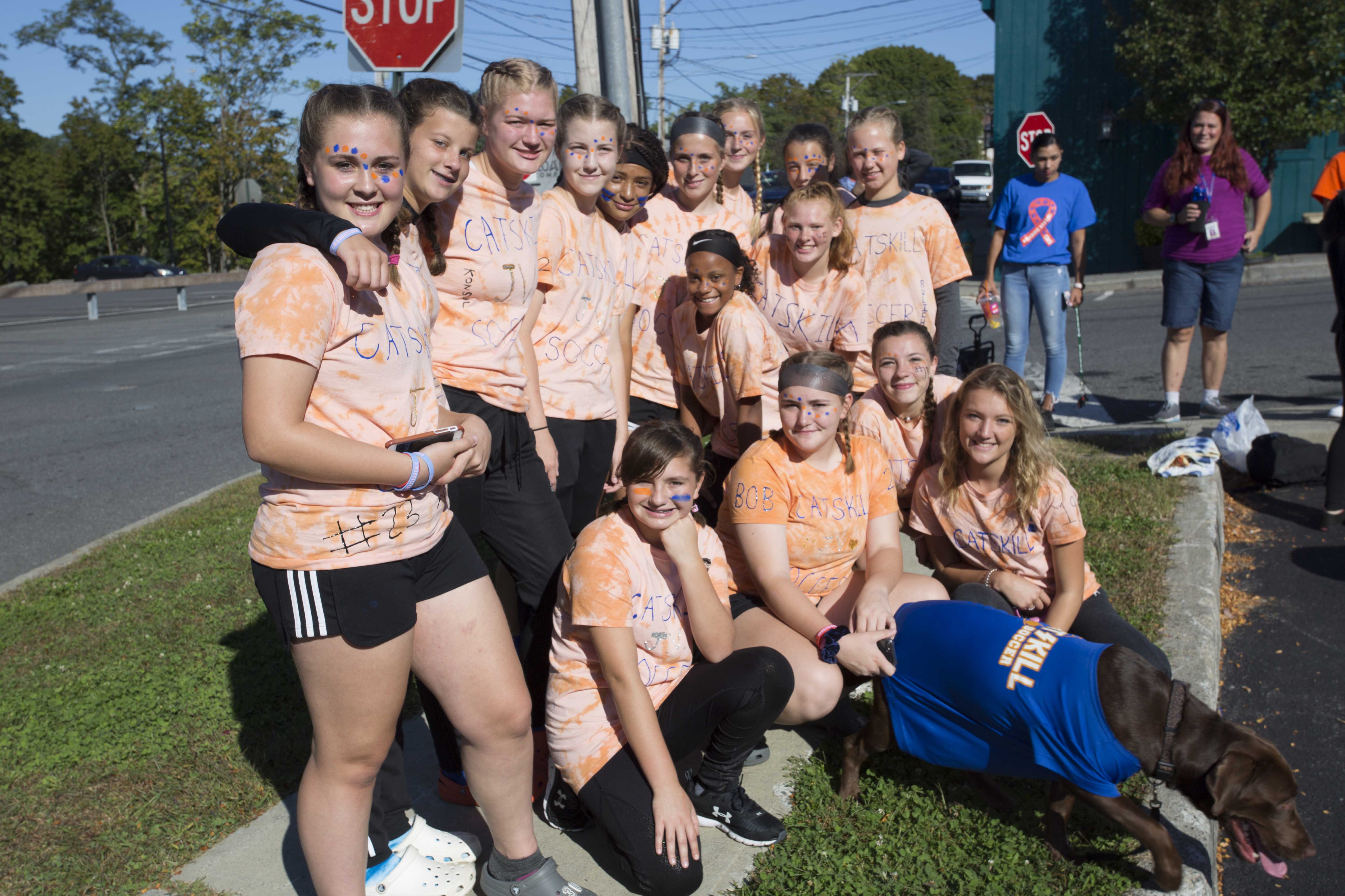 girls sports team photo all wearing orange shirts