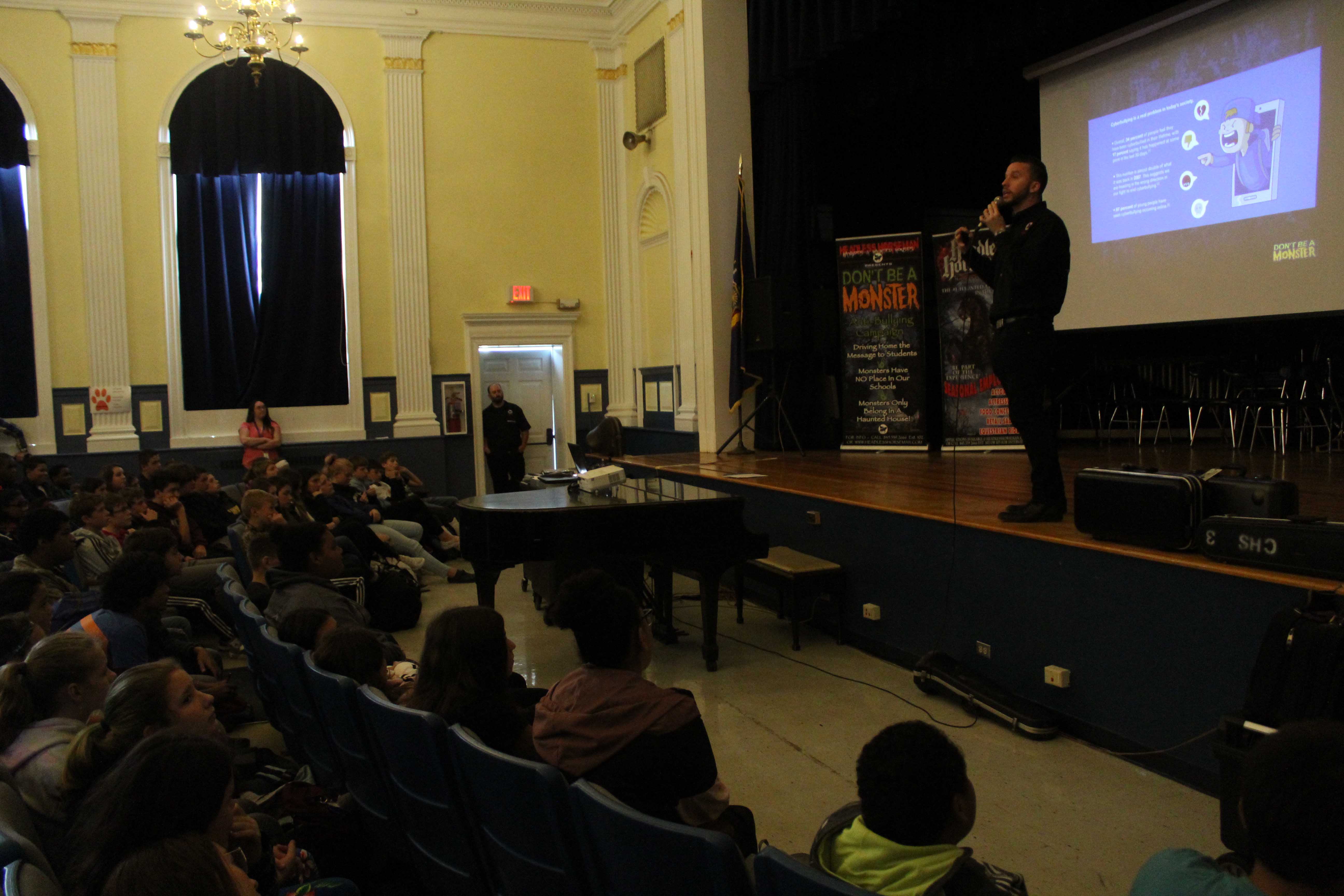 Ryan Dutcher talks to audience of students in auditorium