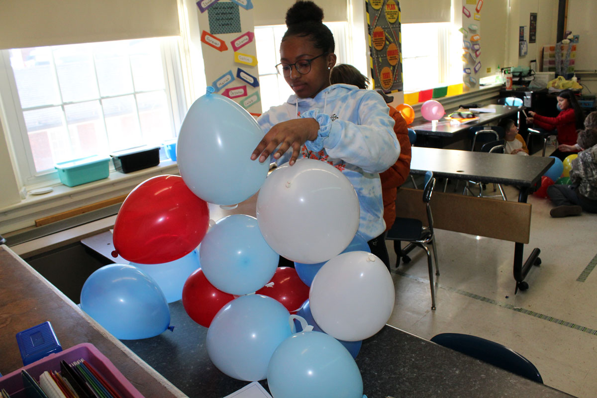 girl building balloon tower