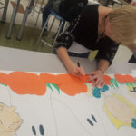 girl working on mural showing pupkins