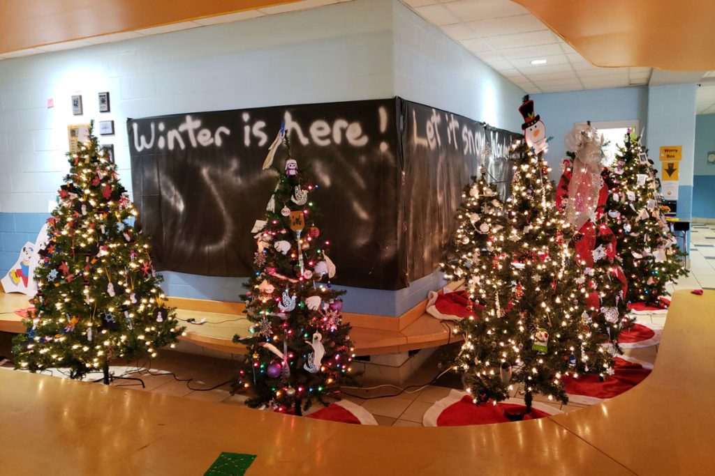 trees in lobby with banner that says winter is here