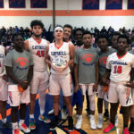 basketball team poses with player holding ball that says 1000 points