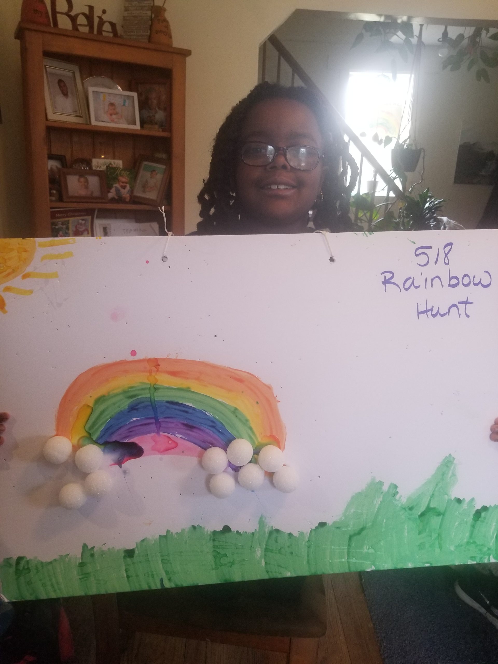 girl holding rainbow drawing