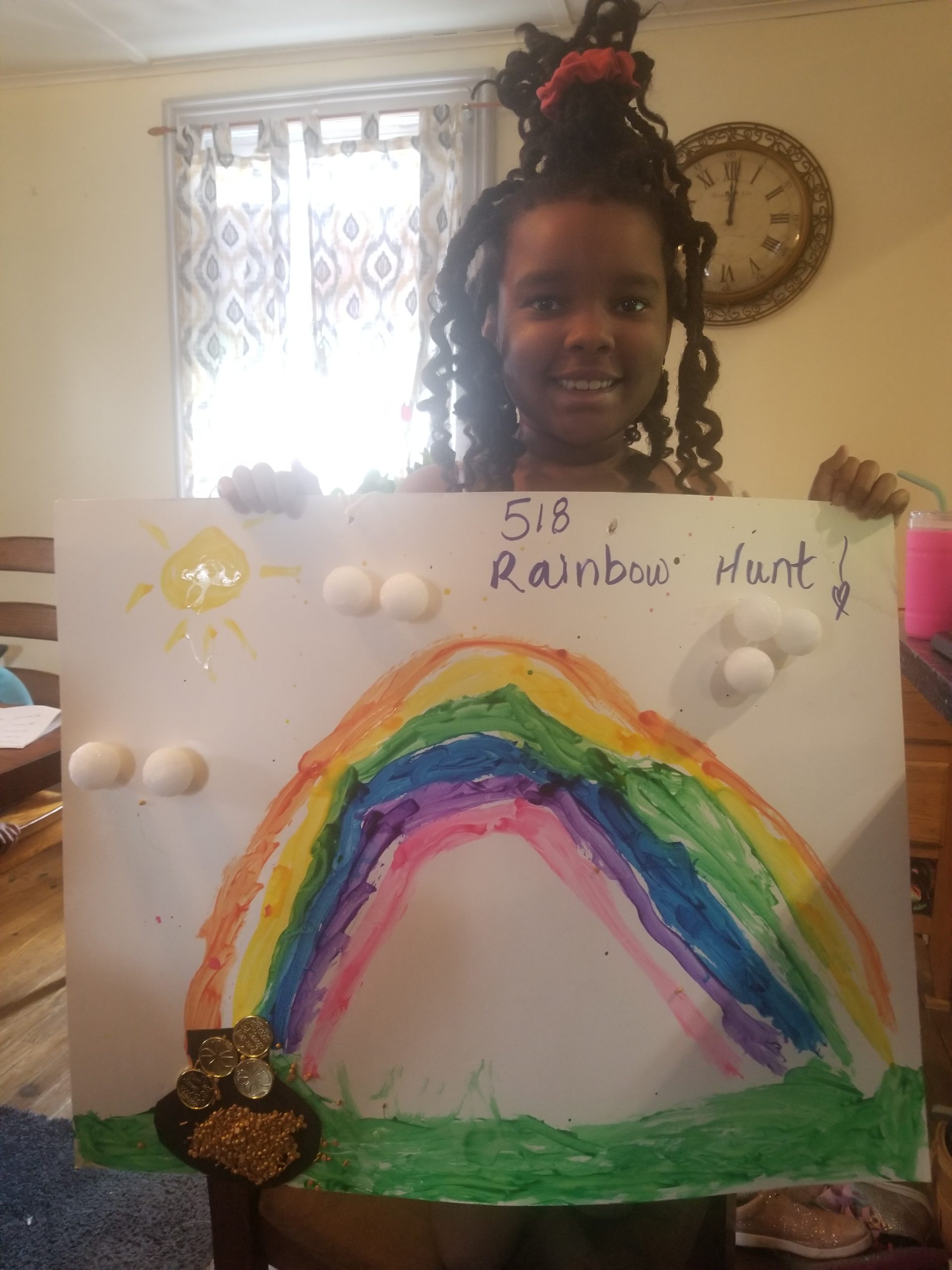 girl holding drawing of rainbow