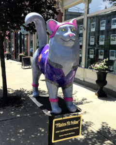 Painted cat on post on street