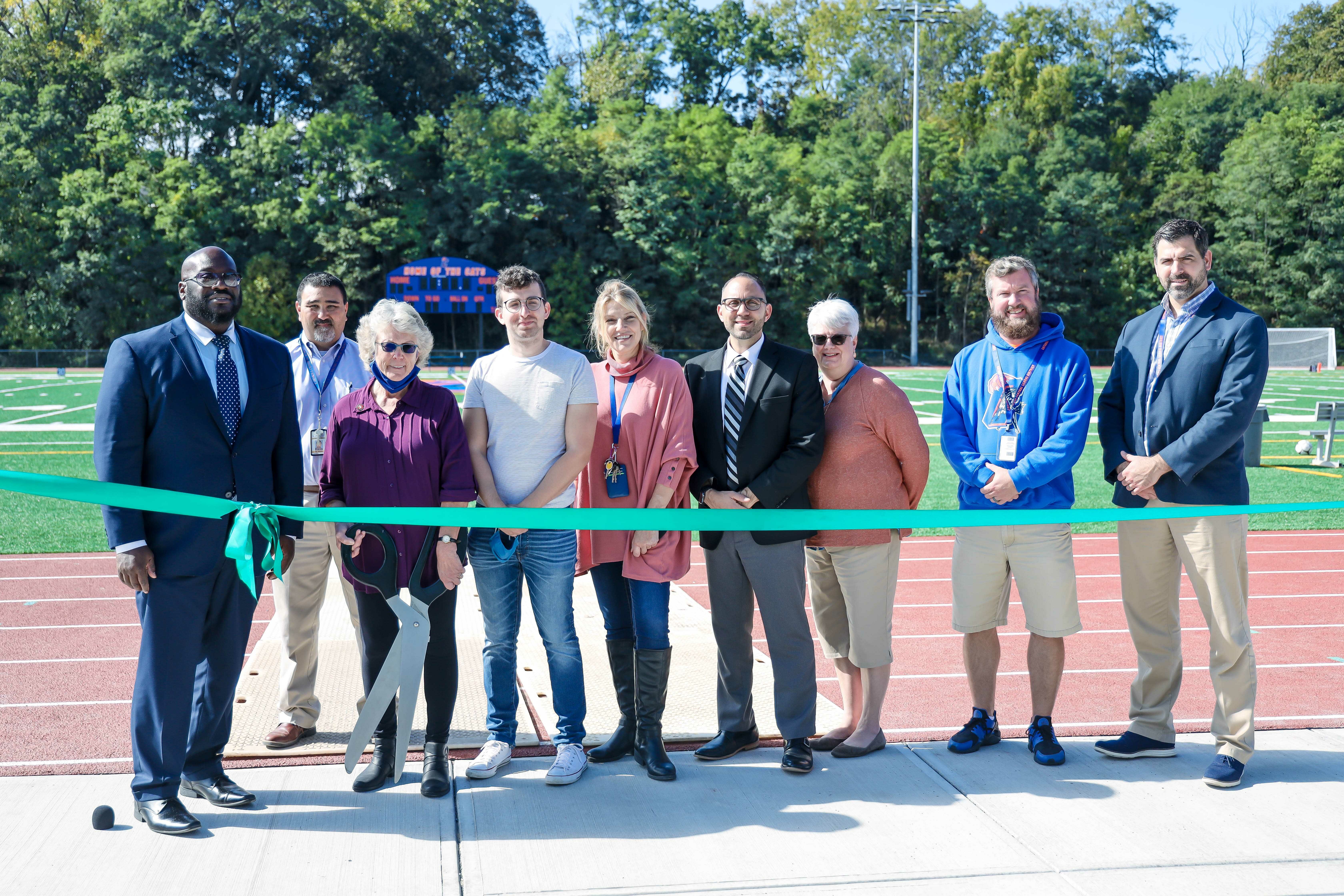 Administrators and Board Members cut ribbon on track and field