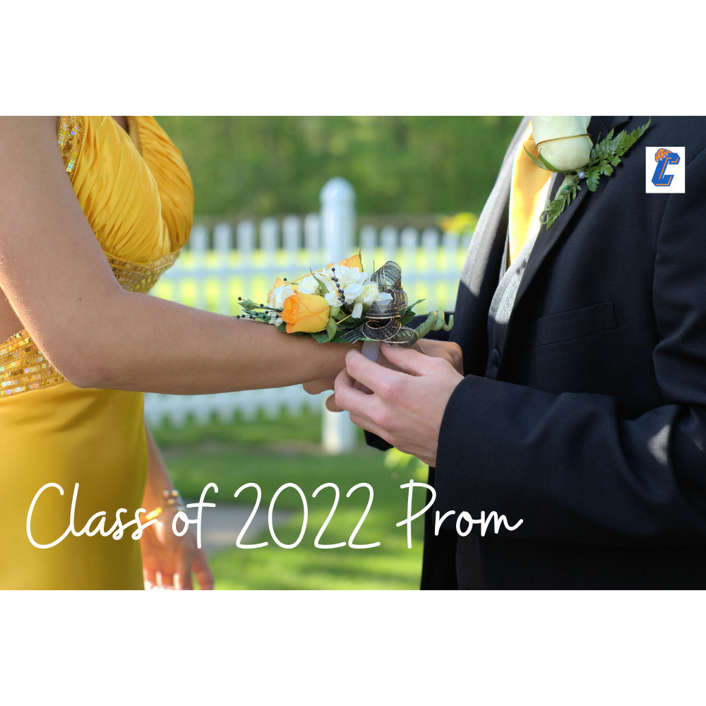 Boy in tux putting corsage on wrist of girl in dress