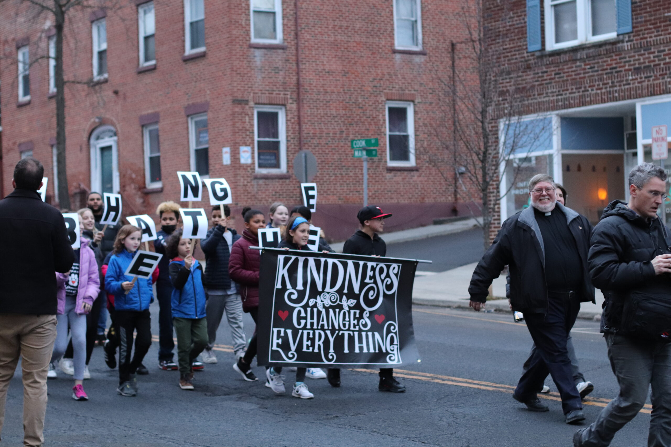 students marching with Kindness Matters banner