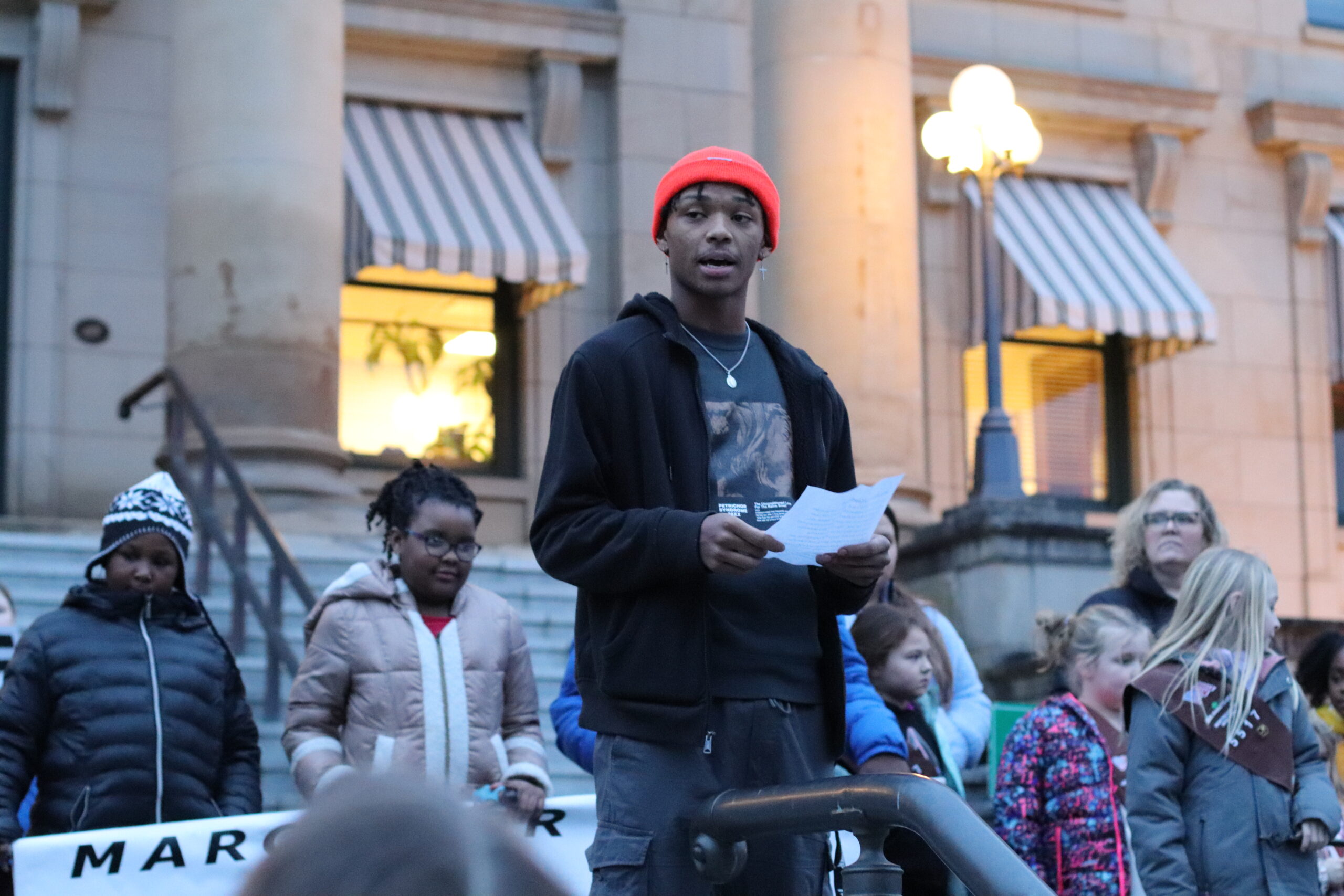 young man speaking on steps of courthouse