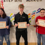 two girls and one boy holding Student of the Month certificates