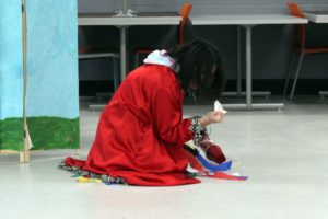 student in red cape performs skit