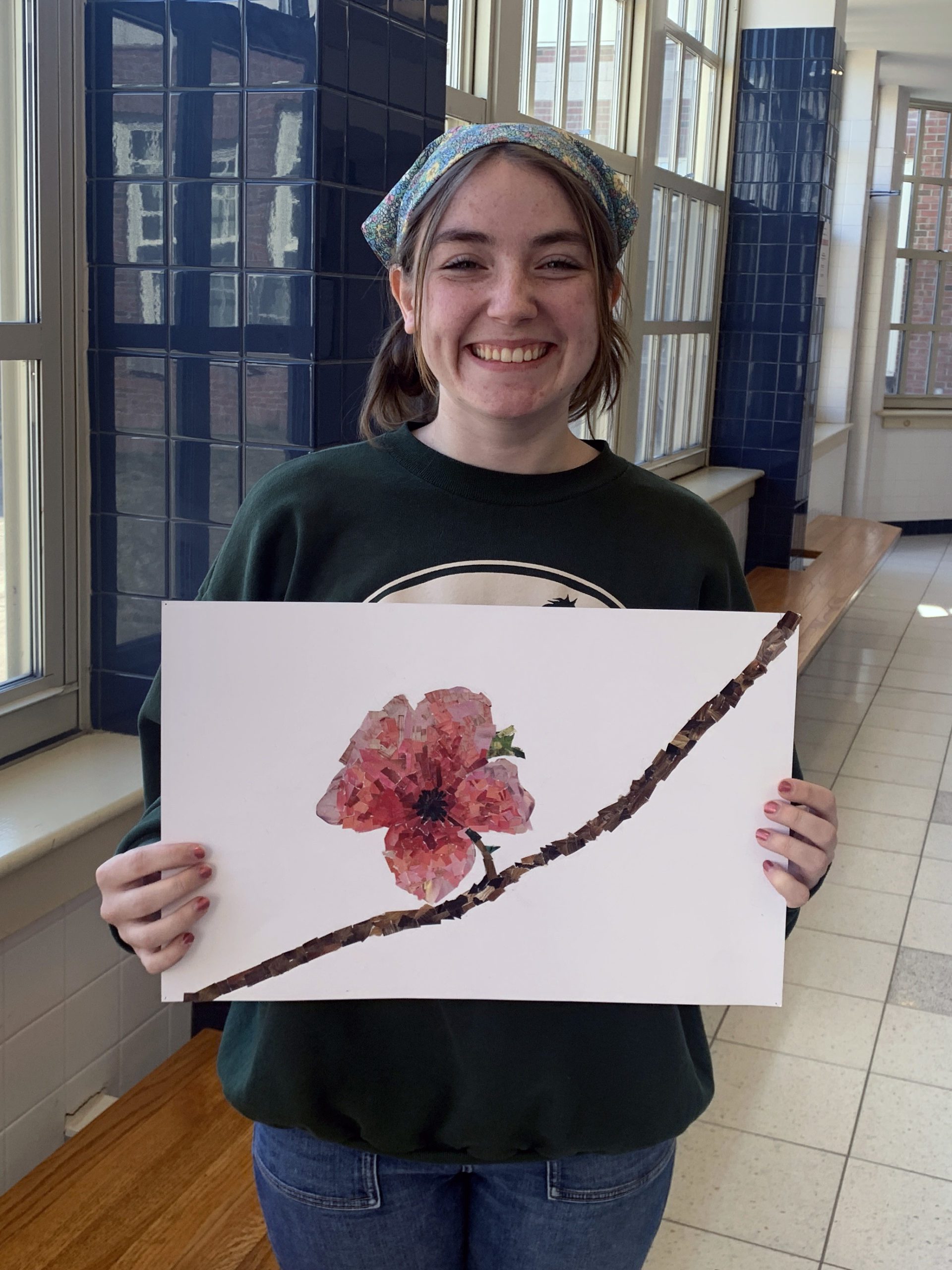 female high school student holding artwork depicting flower