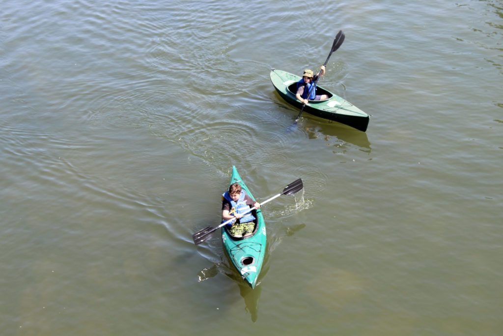 students paddling kayaks