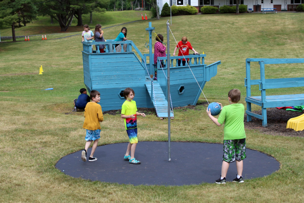 students playing tetherball and playing on ship fort