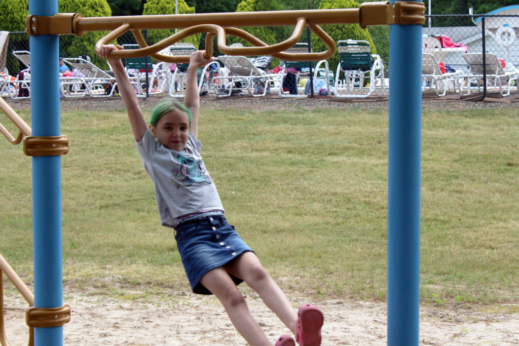 girl swinging on playground equipment