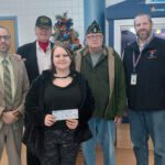girl posing with check and principal, American legion members, and superintendent