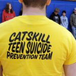 student wearoinf yellow t-shirt that says Catskill Teen Suicide Prevention Team