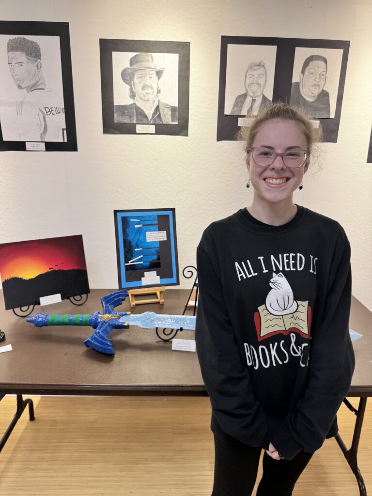 girl smiling in front of paintings on wall