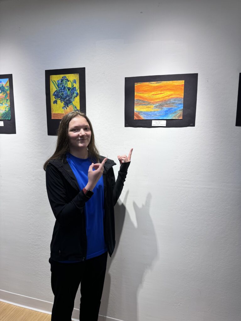 girl pointing to painting on wall