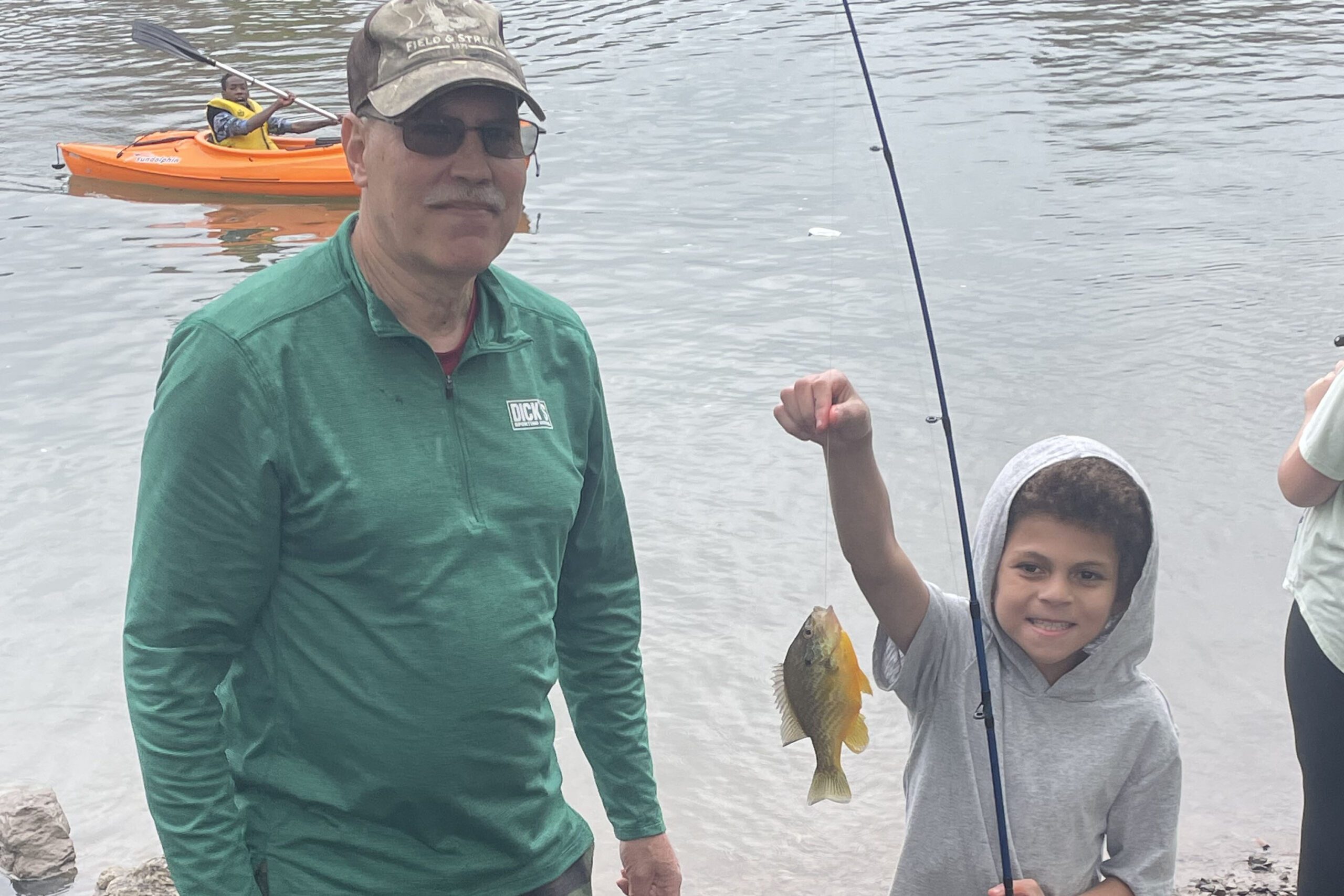 boy holding up fish on line
