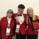Three students in FCCLA uniforms pose for photo.